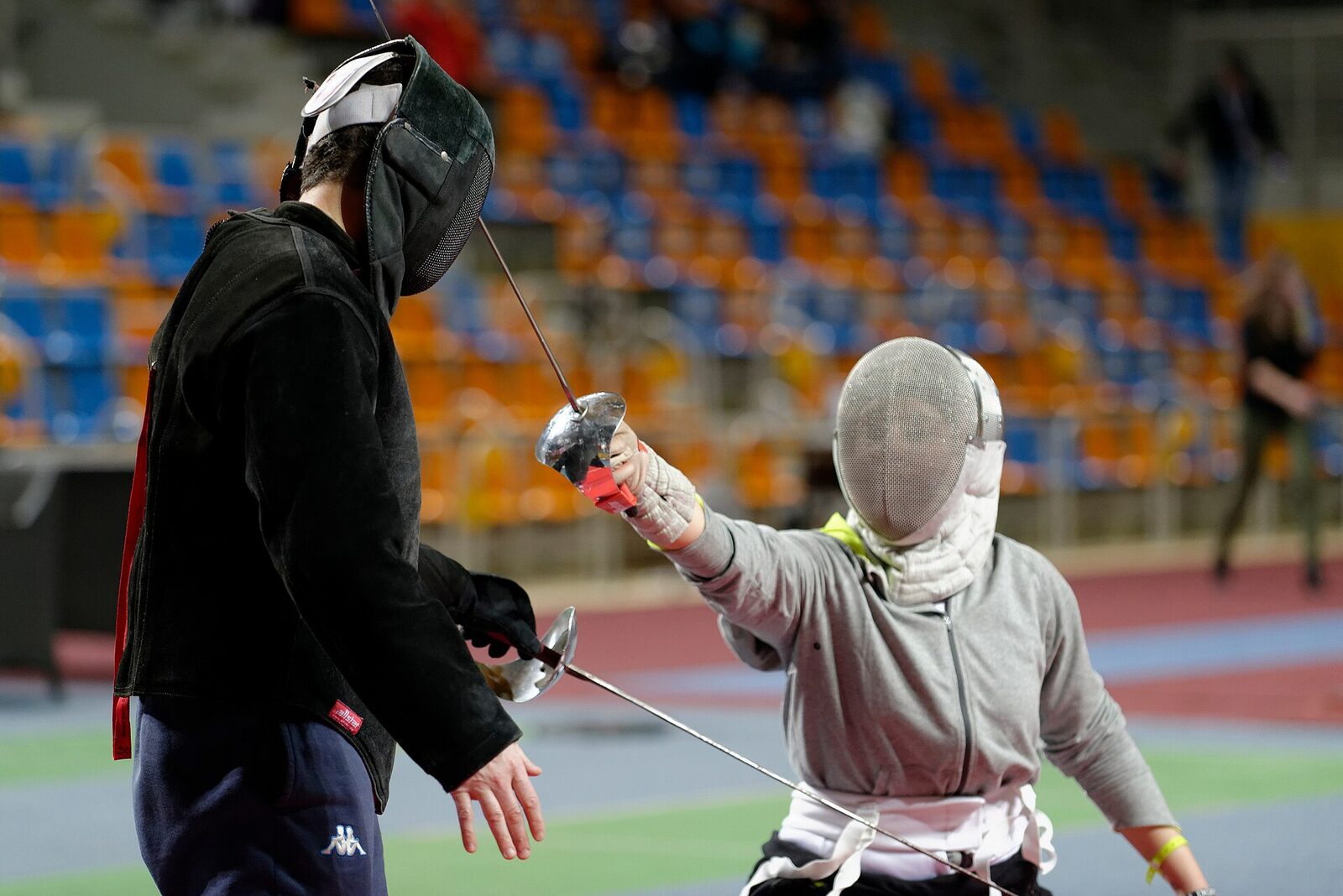 A coach gives a fencer a one-on-one saber lesson